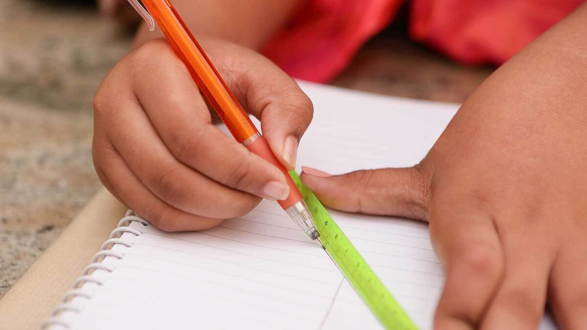 student drawing graph with ruler