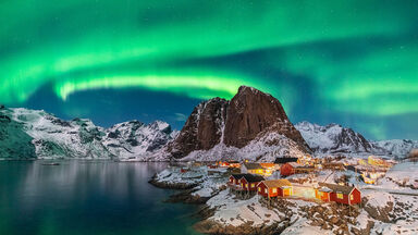 Northern lights above Festhelltinden peak and Hamnoy Norway