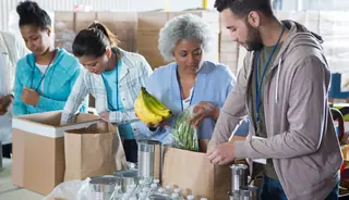 four volunteers packing food as a humanitarian example