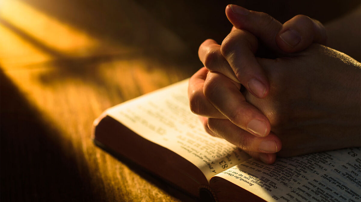 hands praying on Bible Beatitudes