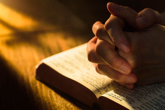 hands praying on Bible Beatitudes