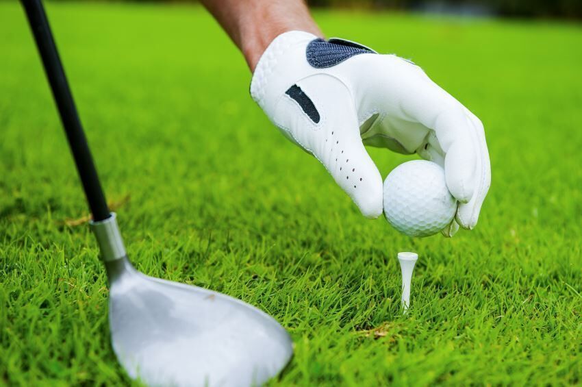 golfer puts ball on tee