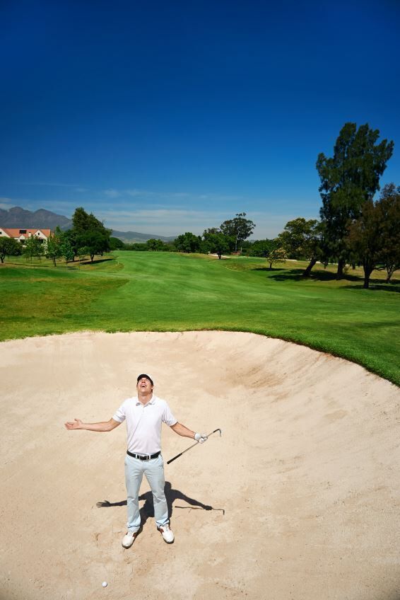 frustrated golfer in sand trap