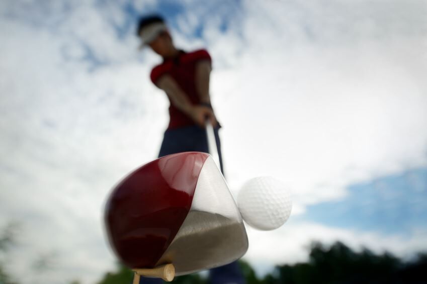 golfer strikes ball
