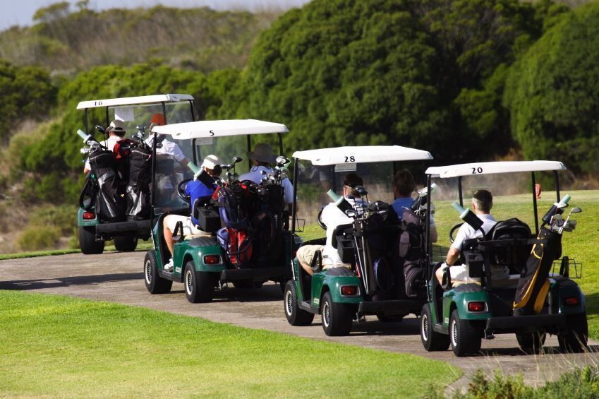 golf carts drive down a path