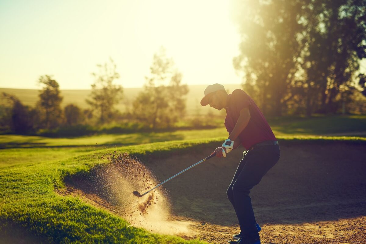 Golfer hitting out of bunker