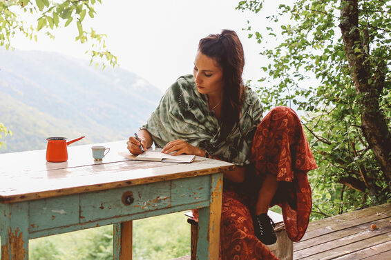 woman writing outdoors at table