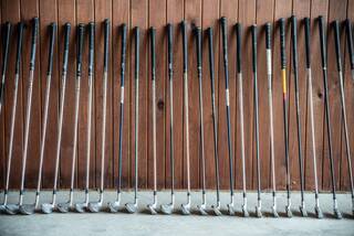 Golf clubs rest against a wall