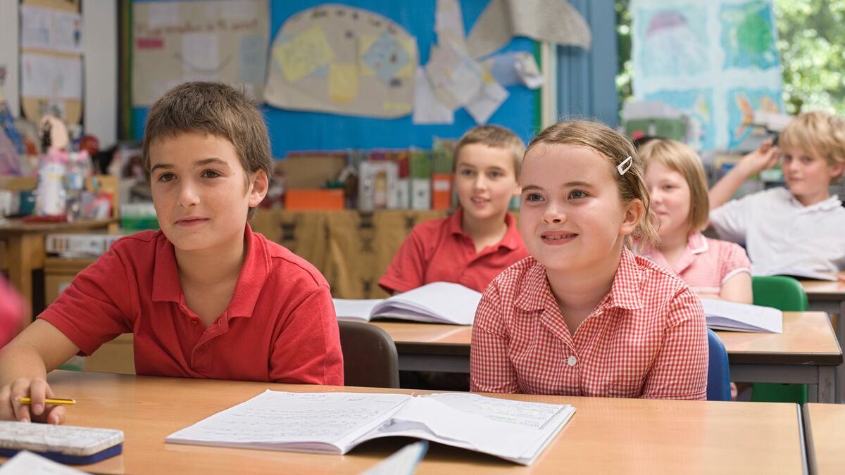 third grade students with worksheets