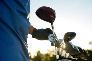 Golfer pulling driver out of club bag