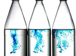 Blue food coloring diffusing in bottled water