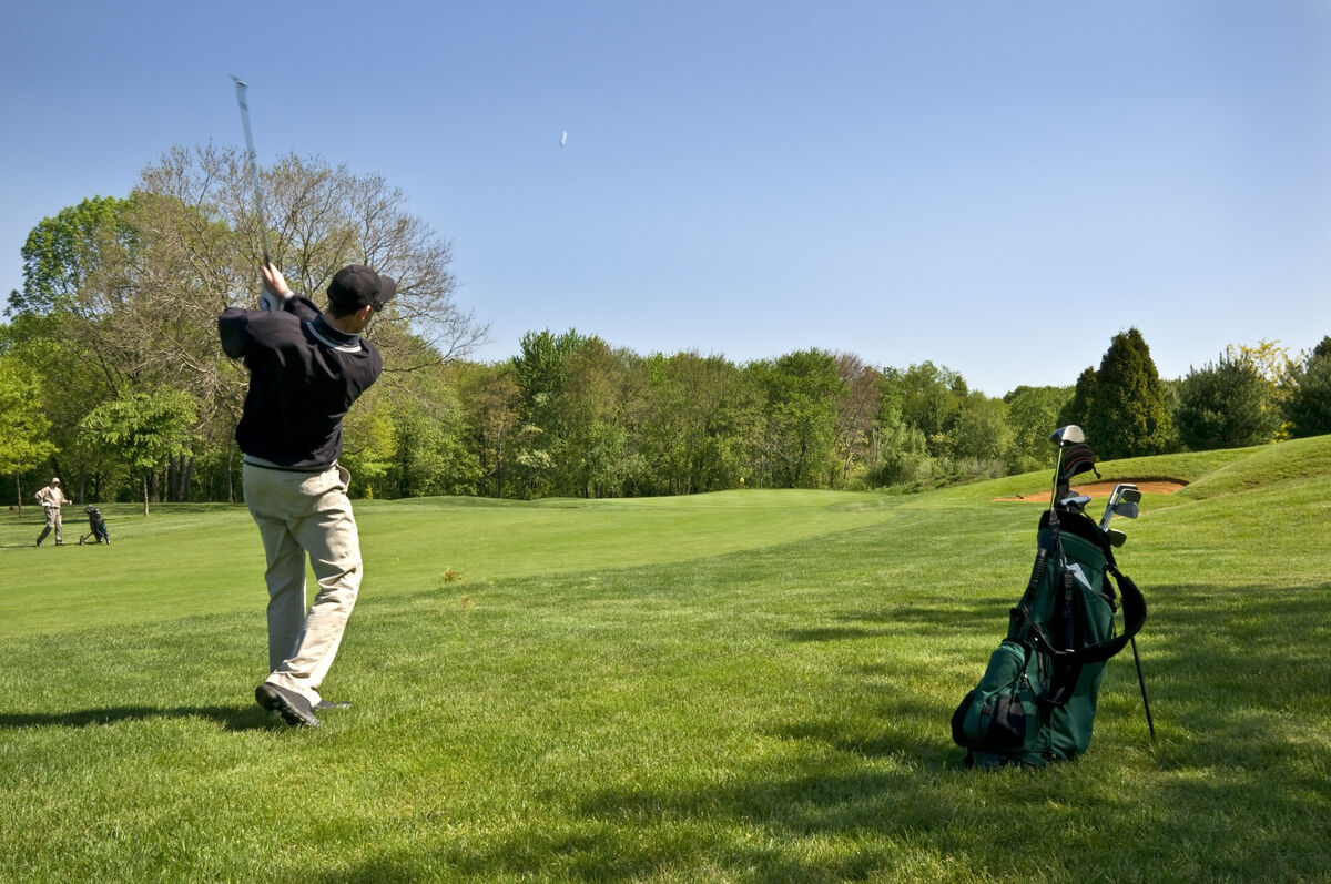 two golfers on opposite sides of the fairway