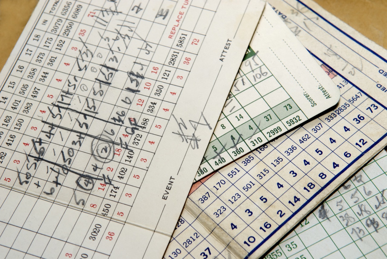 A stack of old golf scorecards