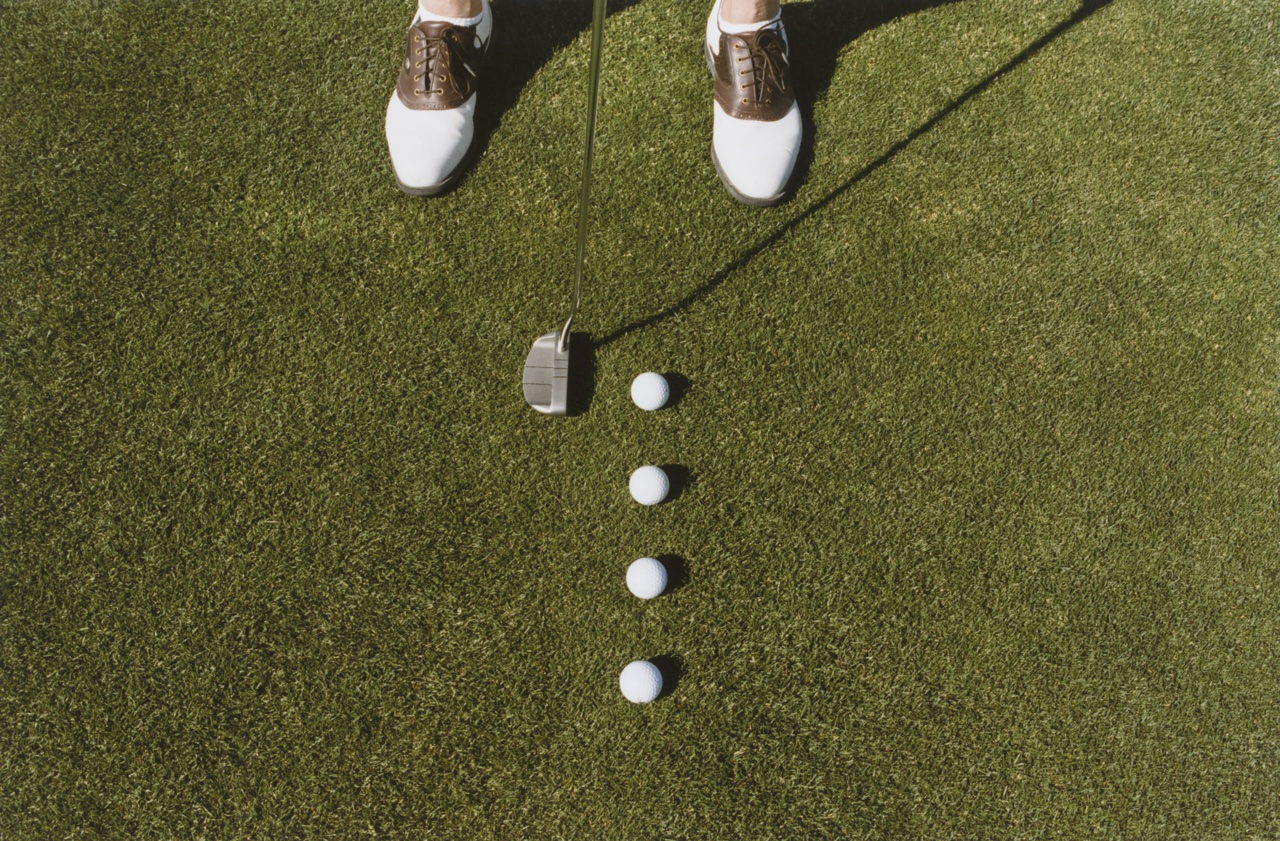 Golfer putts with four balls lined up