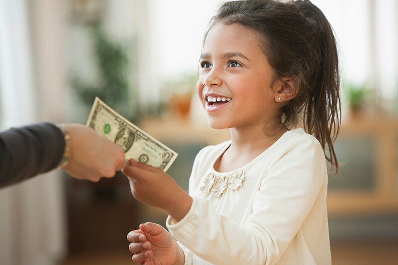 child being handed allowance