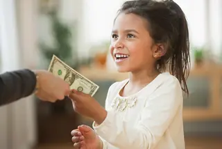 child being handed allowance