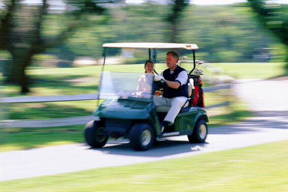 Golfers driving golf cart fast