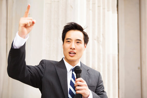 Man waving finger and holding microphone as declamation example