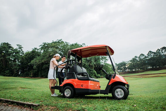 Couple placing bags on golf cart