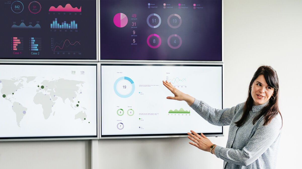 Businesswoman Explaining Data On Large Monitors as Data Singular or Plural Examples