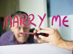 man writing Marry Me on mirror in lipstick