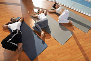 three young people performing supine spinal twist