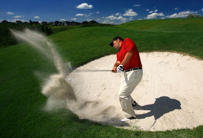 golfer hitting from bunker