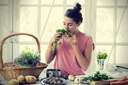 Young woman smelling wild herbs vignette