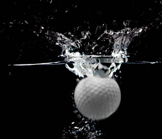 Golf ball splashing in water