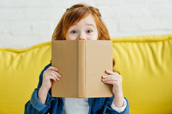 Girl on sofa reading a book