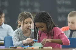 Students stacking blocks in the classroom