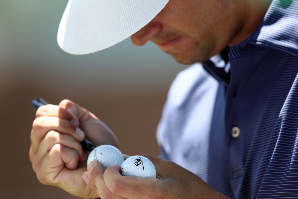 Professional golfer marks golf balls
