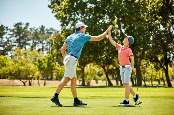 Father and son golfers high-five after a milestone round