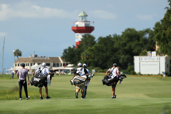 Players and caddies walk up the 18th at the RBC Heritage