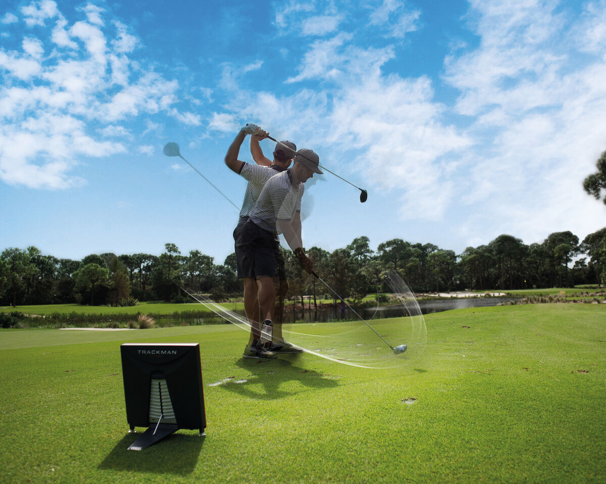 Golfer using Trackman system on monitor
