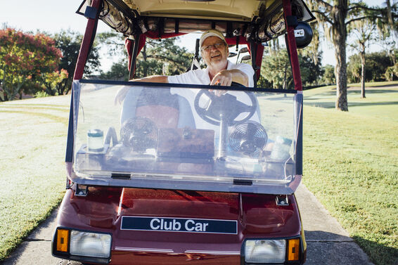 Old man driving golf cart