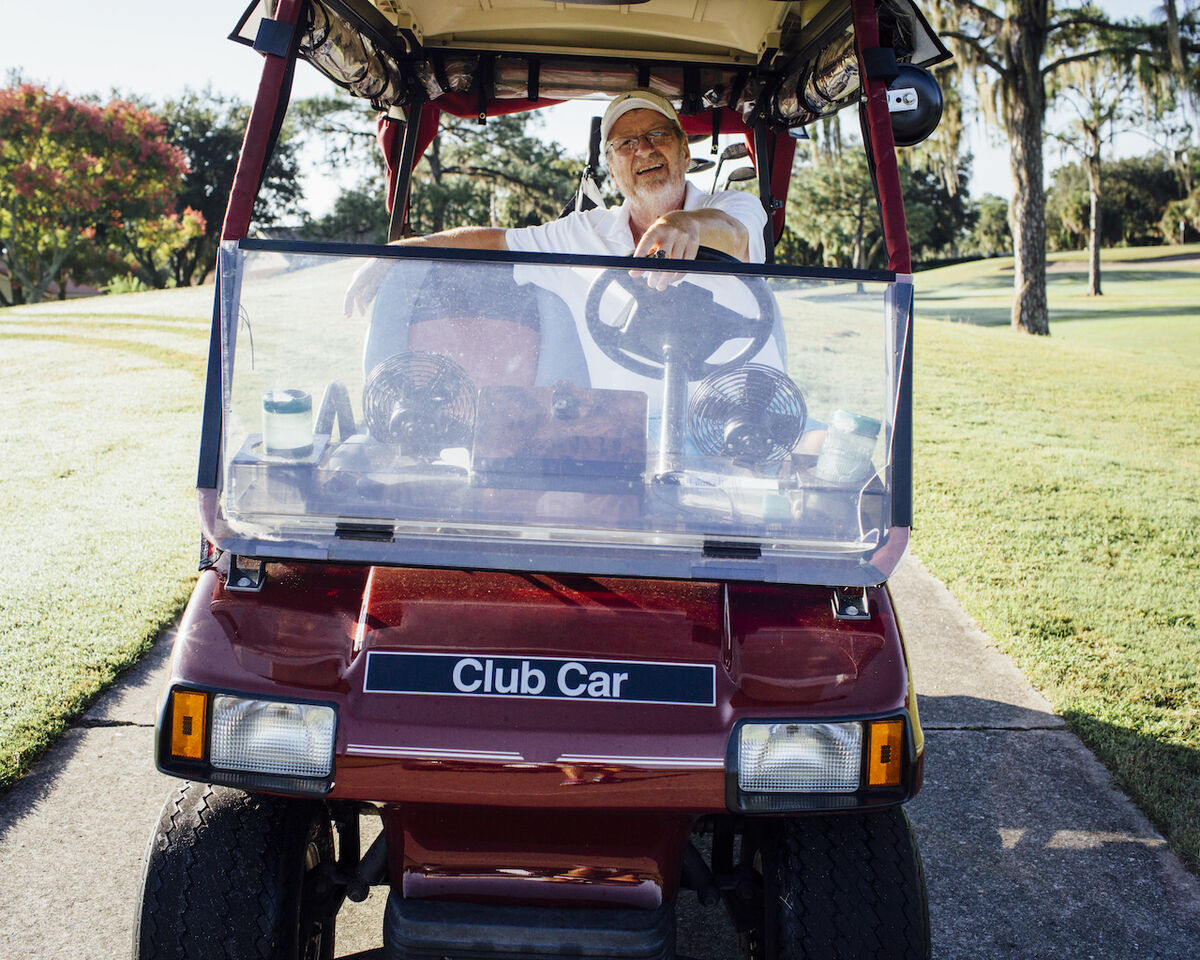 Old man driving golf cart
