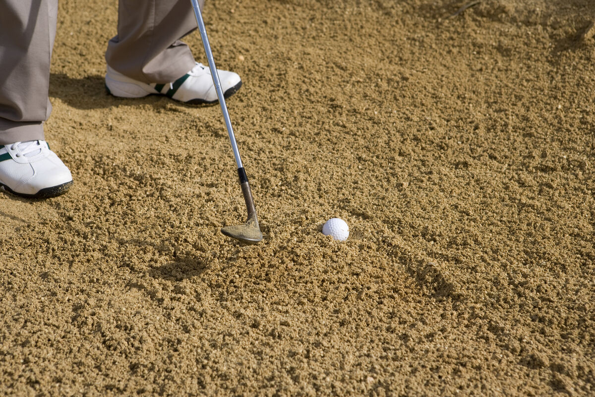 Golf ball in a fried egg lie in the bunker