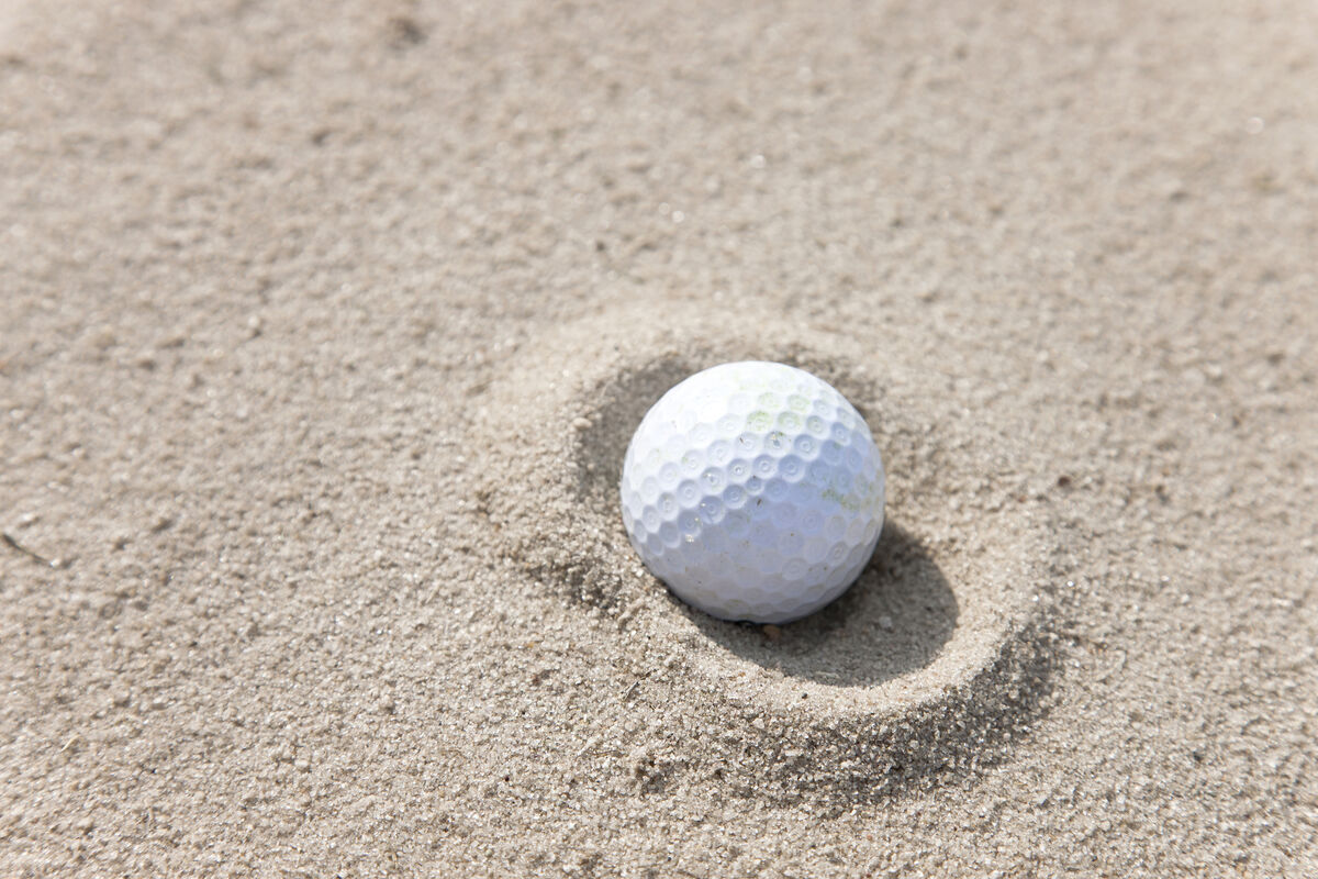 Golf ball in a fried egg lie in the bunker
