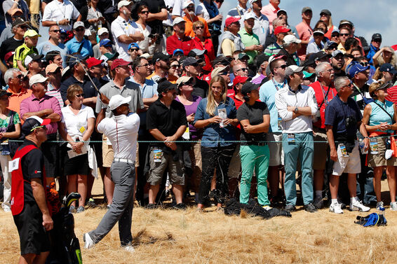 Tiger Woods hitting shot next to fans