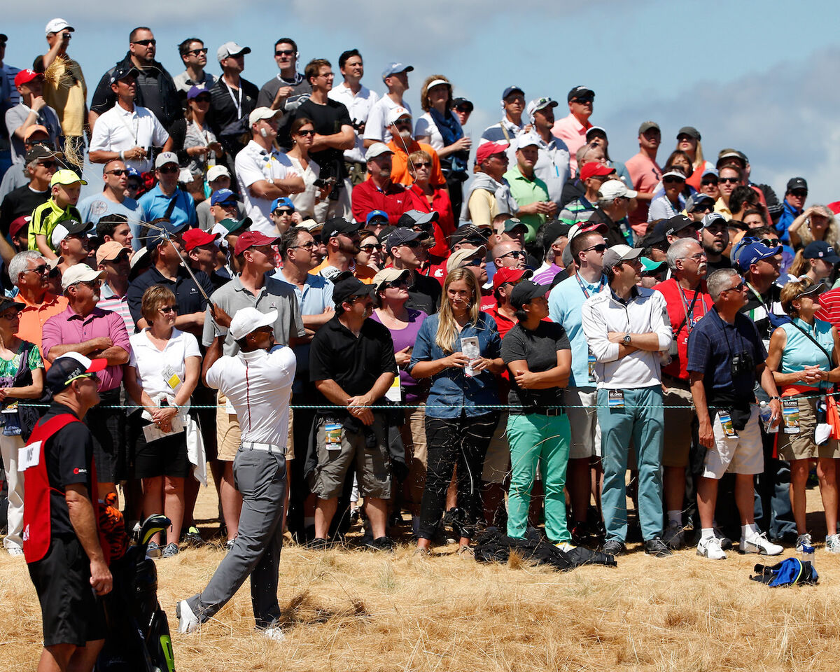 Tiger Woods hitting shot next to fans
