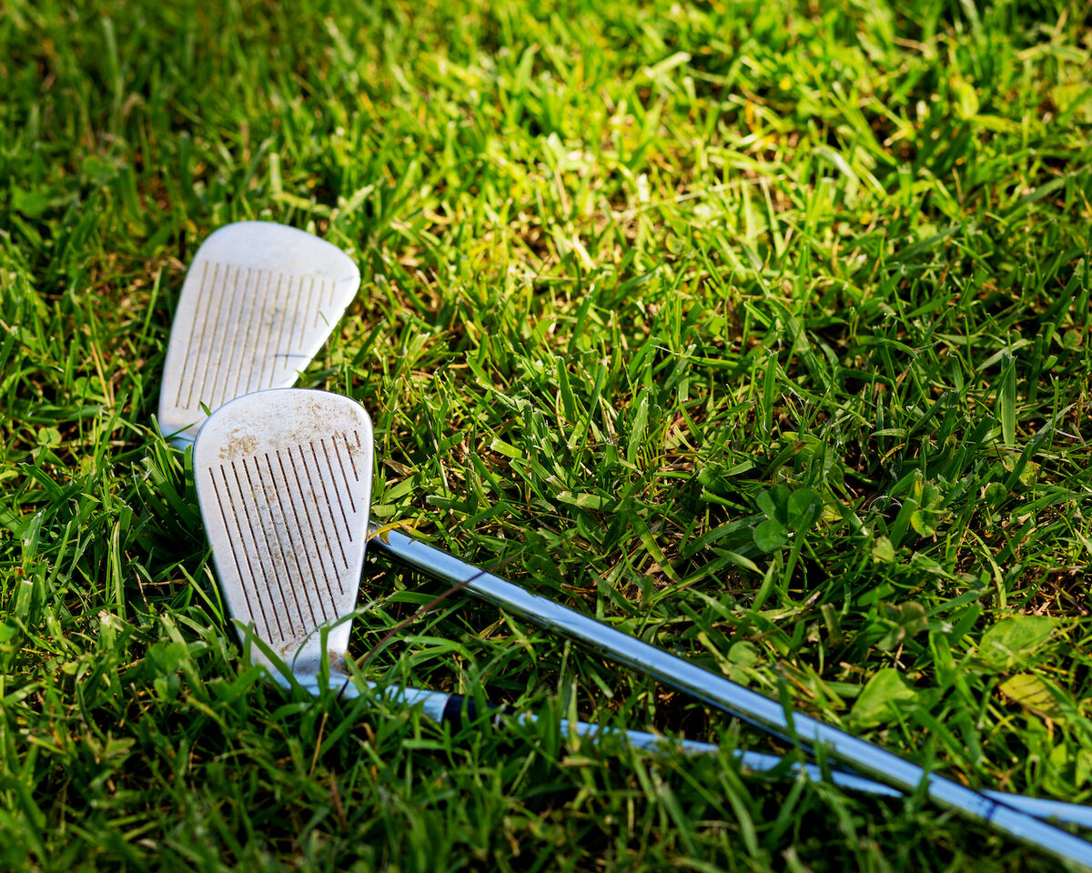 Dirty golf clubs on grass