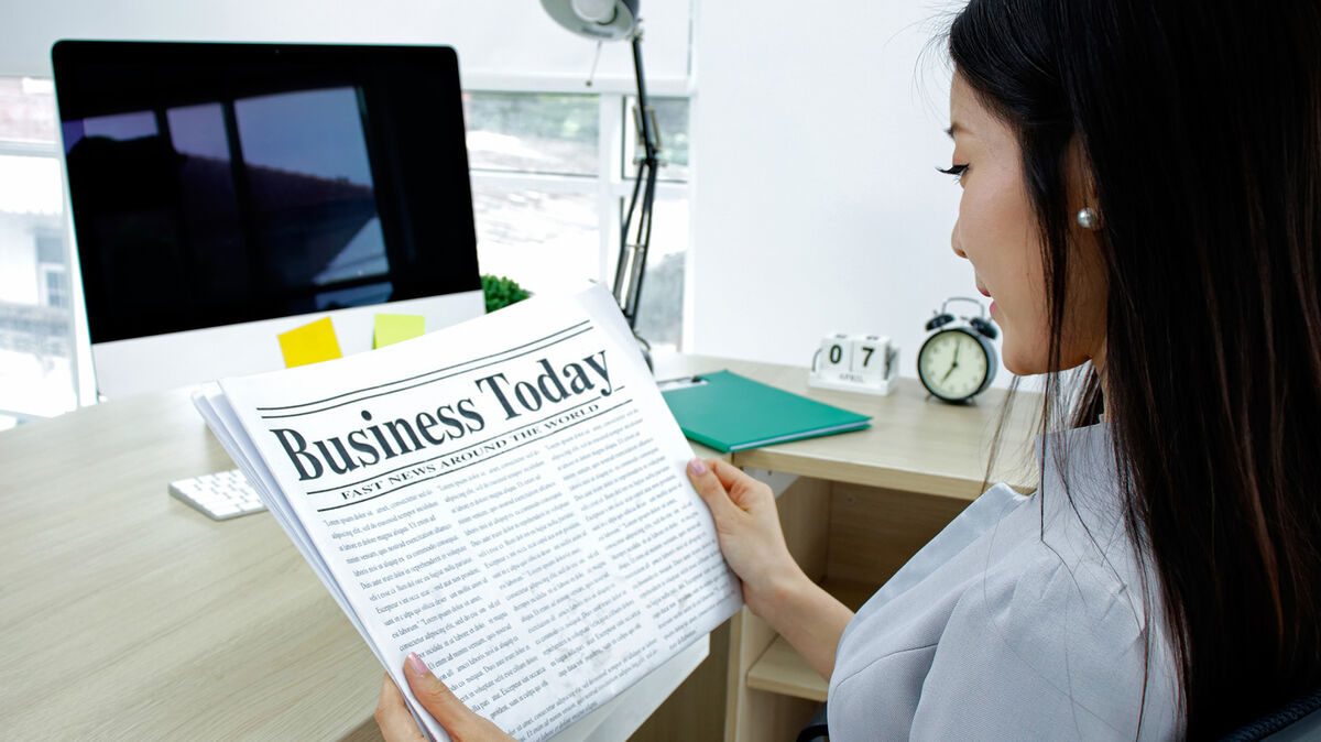 Businesswoman reading a newspaper in office