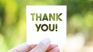 fingers holding a paper with Thank You message