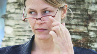 Woman pushing up eyeglasses giving side-eye