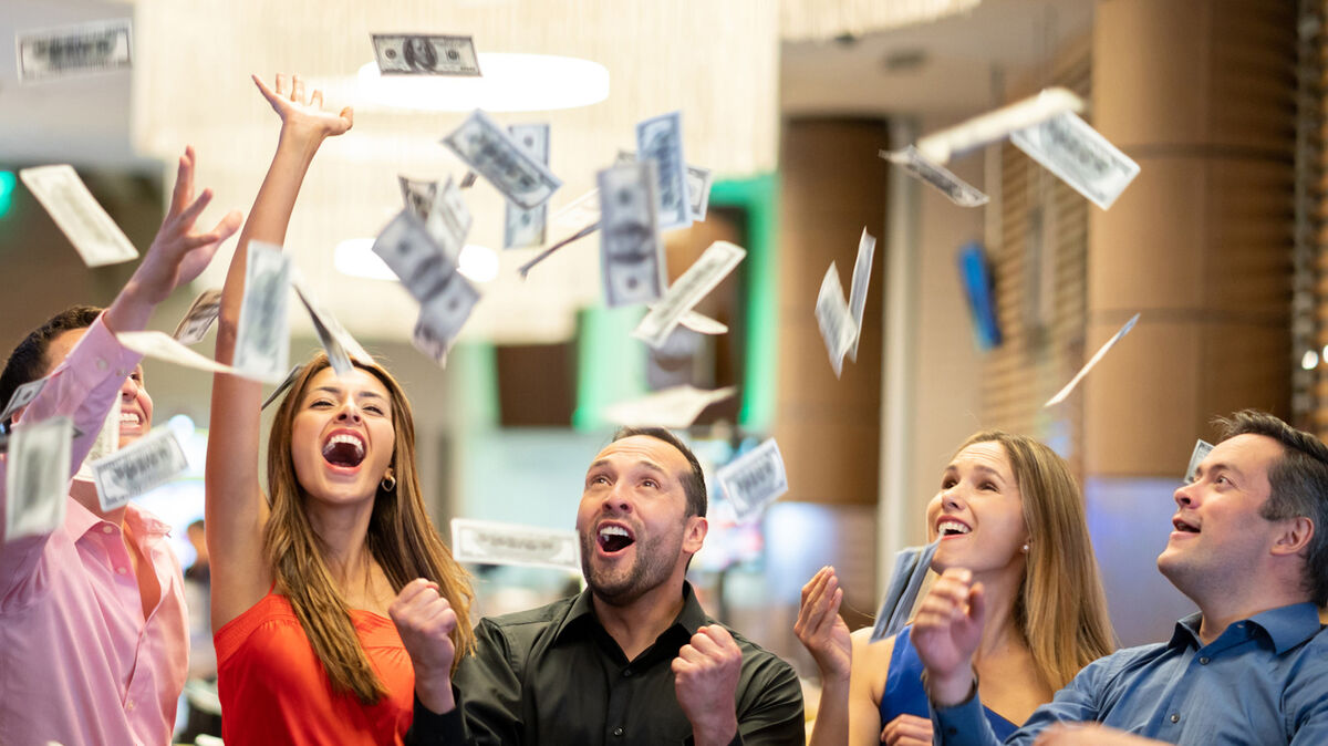 Group of friends throwing money in the air