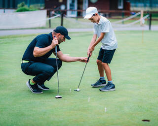 Young golfer receiving lessons