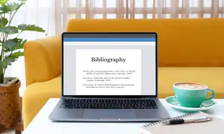 Laptop computer bibliography on screen on table with coffee
