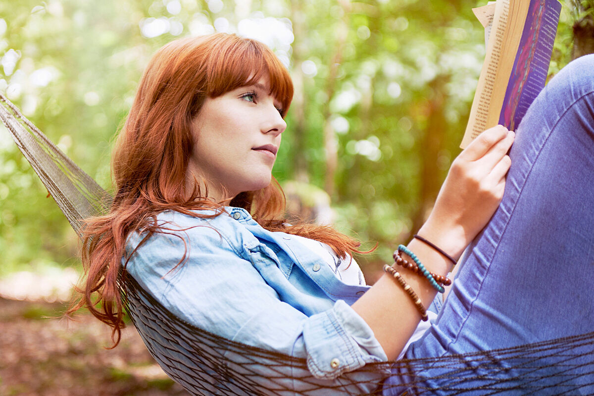 Woman in hammock reading book