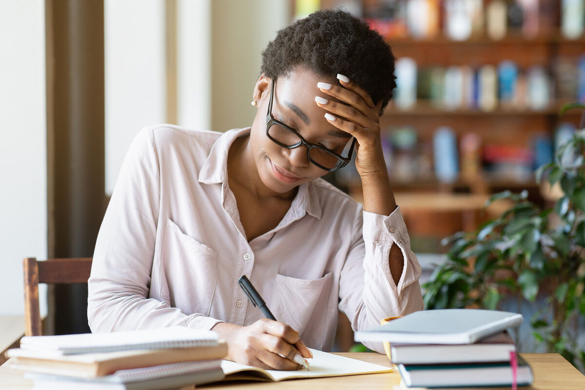 Woman with pile of books studying